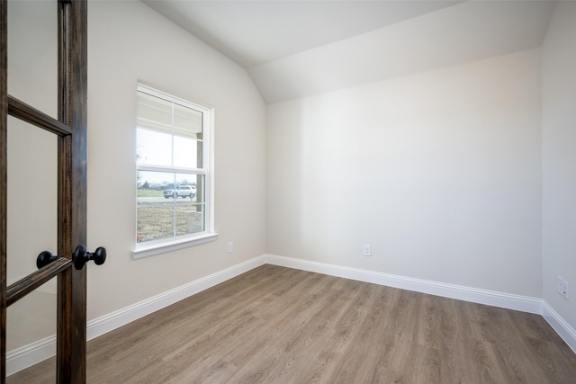 empty room featuring lofted ceiling and light wood-type flooring