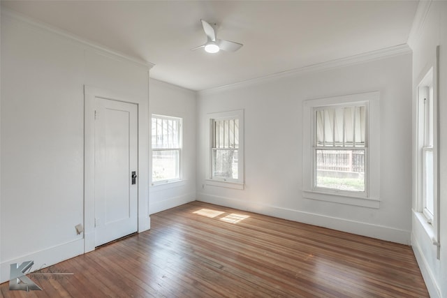 empty room with crown molding, wood-type flooring, and ceiling fan