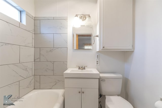 bathroom featuring vanity, a bath, and toilet