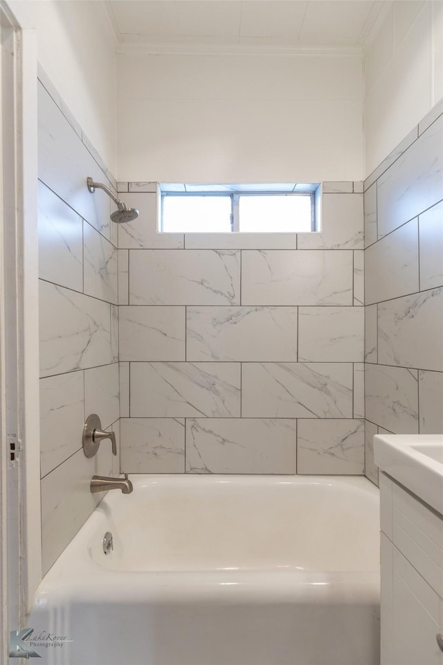 bathroom featuring tiled shower / bath combo, ornamental molding, a healthy amount of sunlight, and vanity