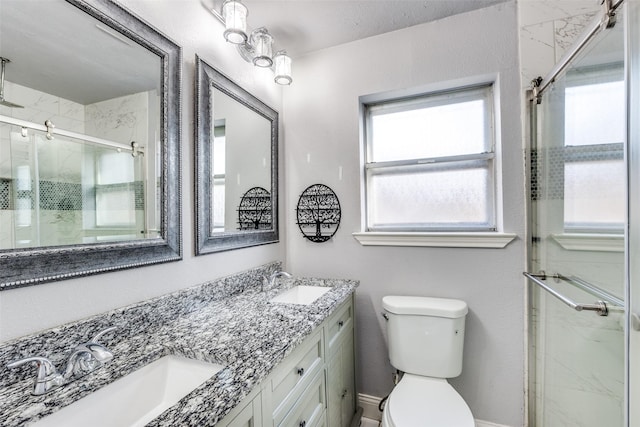 bathroom featuring vanity, a shower with door, and toilet