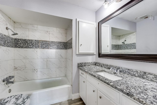 bathroom with vanity, hardwood / wood-style floors, and tiled shower / bath combo