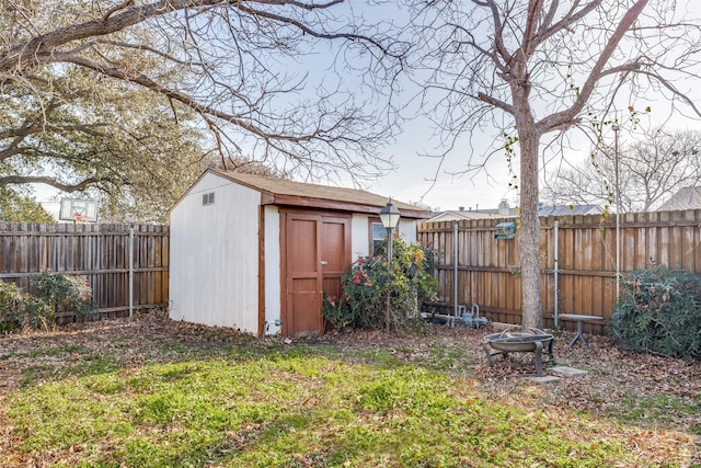 view of outbuilding featuring a yard and an outdoor fire pit