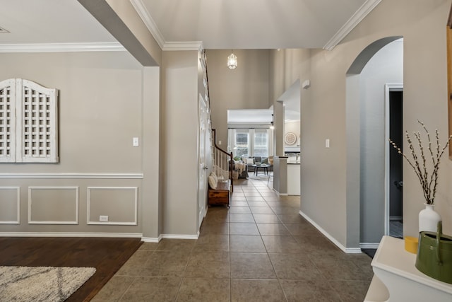 hallway featuring ornamental molding and dark tile patterned floors