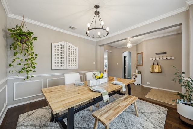 dining room with crown molding, dark hardwood / wood-style floors, and a notable chandelier