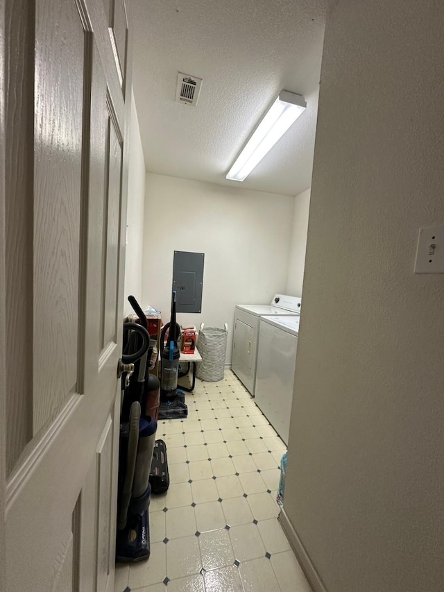 washroom with electric panel, washing machine and dryer, and a textured ceiling