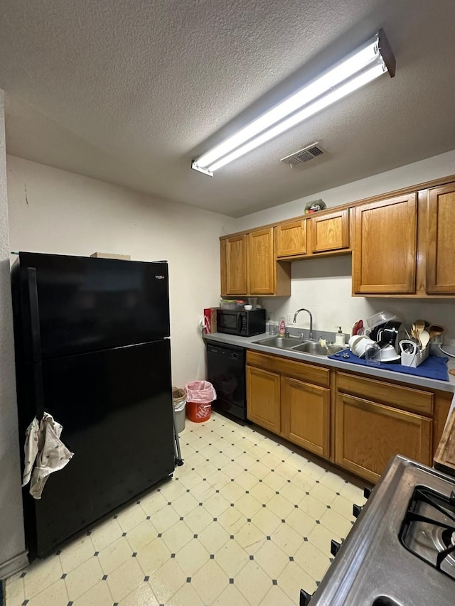 kitchen featuring sink, a textured ceiling, and black appliances