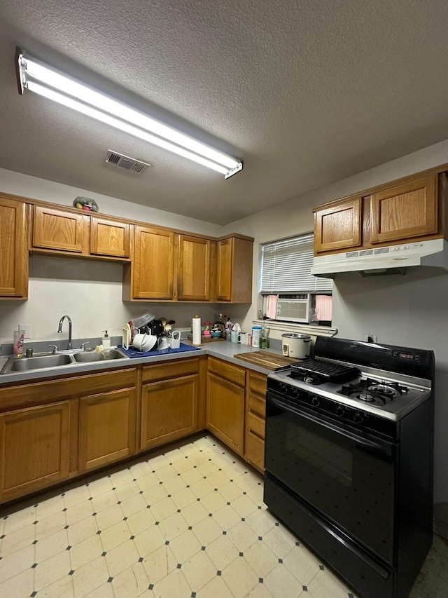 kitchen with black gas stove, sink, and a textured ceiling