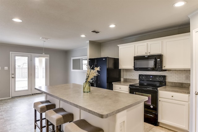 kitchen featuring white cabinetry, a center island, and black appliances