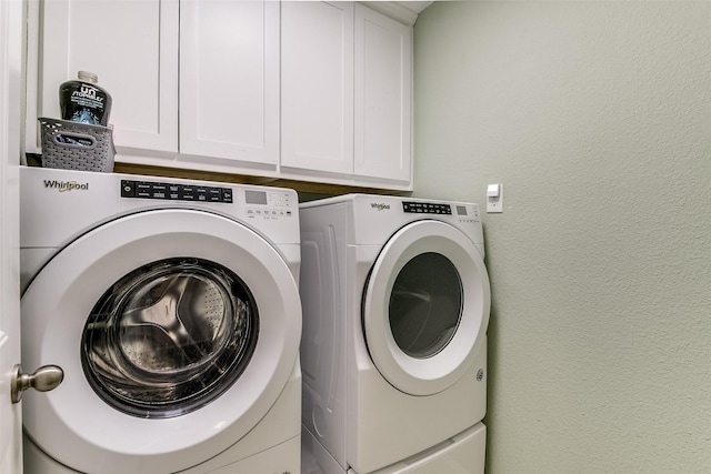 laundry room featuring cabinets and washing machine and clothes dryer