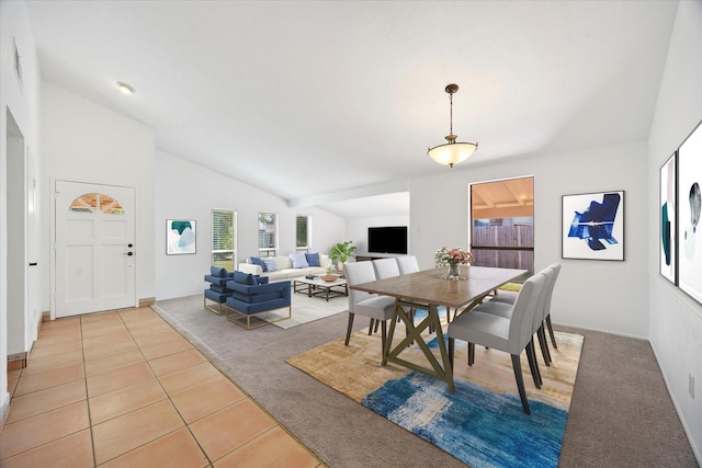 dining area featuring lofted ceiling and light tile patterned flooring