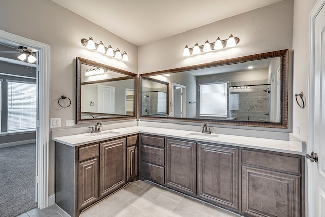 bathroom featuring ceiling fan, vanity, and a shower