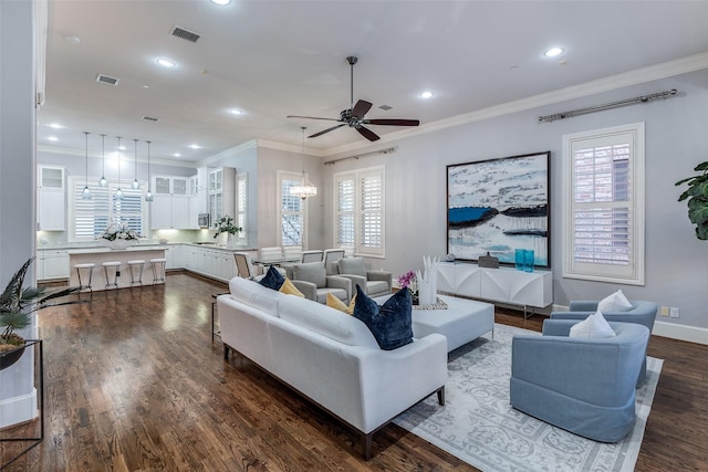 living room featuring ceiling fan, ornamental molding, and dark hardwood / wood-style floors