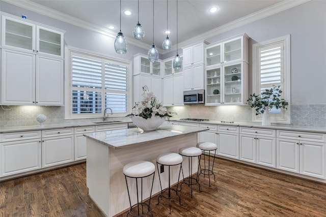 kitchen with a kitchen island, appliances with stainless steel finishes, sink, and white cabinets