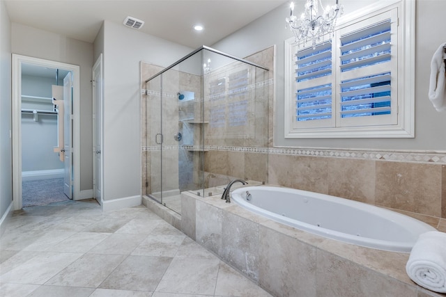 bathroom with an inviting chandelier, tile patterned floors, and shower with separate bathtub