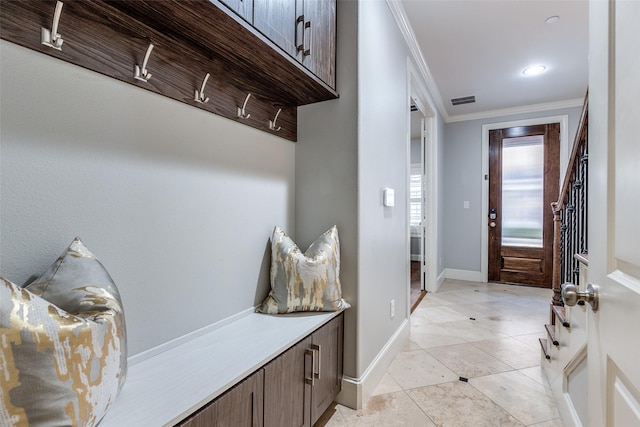 mudroom with light tile patterned floors and crown molding