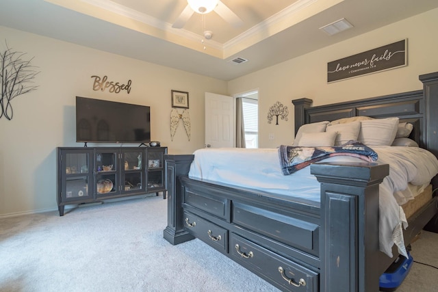 bedroom with ceiling fan, ornamental molding, a raised ceiling, and light carpet