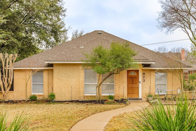 ranch-style house featuring brick siding and roof with shingles