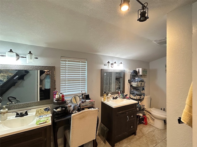 1321 Hall St, Lancaster, TX 75134 - full bath with toilet, a textured ceiling, a textured wall, two vanities, and tile patterned floors