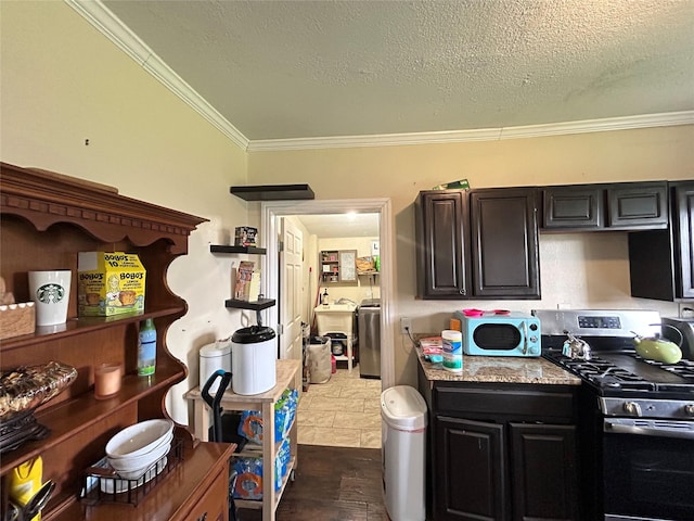 1321 Hall St, Lancaster, TX 75134 - kitchen featuring gas range, crown molding, washer / dryer, and a textured ceiling