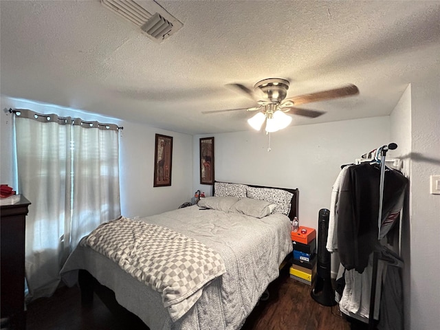 1321 Hall St, Lancaster, TX 75134 - bedroom with dark wood-style floors, a textured ceiling, and a ceiling fan