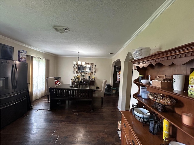 1321 Hall St, Lancaster, TX 75134 - dining space featuring a textured ceiling, arched walkways, a chandelier, ornamental molding, and wood finished floors
