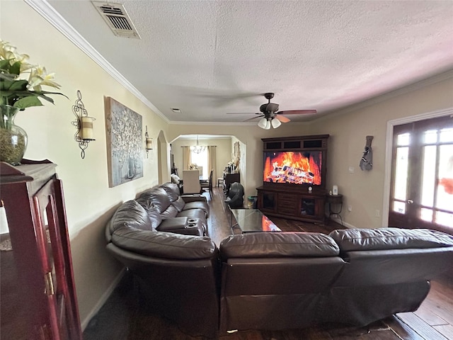 1321 Hall St, Lancaster, TX 75134 - living area featuring a textured ceiling, a ceiling fan, ornamental molding, arched walkways, and baseboards