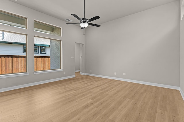 unfurnished room featuring light wood finished floors, baseboards, visible vents, and a wealth of natural light