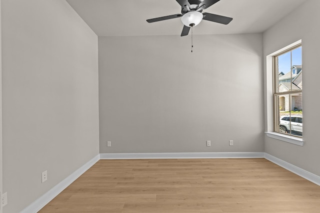 empty room with ceiling fan, light wood-type flooring, and baseboards