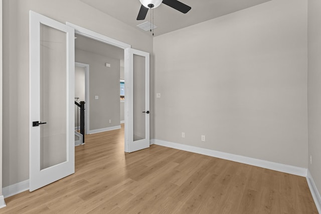 empty room featuring visible vents, ceiling fan, light wood-type flooring, and baseboards
