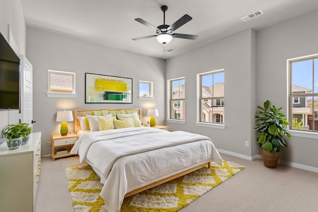 bedroom with visible vents, baseboards, ceiling fan, and light carpet