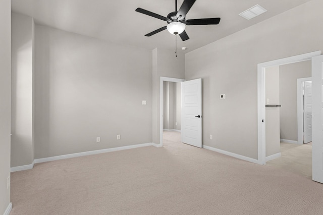 unfurnished room featuring light carpet, visible vents, baseboards, and ceiling fan