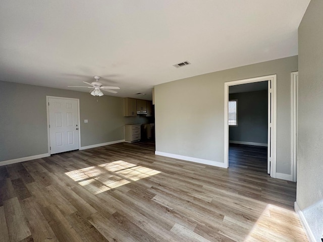 unfurnished living room featuring ceiling fan and light wood-type flooring