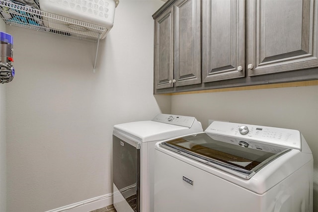 washroom featuring cabinets and washer and clothes dryer