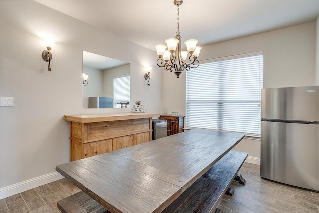 dining space with light hardwood / wood-style flooring and a notable chandelier