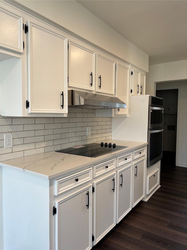 kitchen featuring dark wood-type flooring, white cabinets, under cabinet range hood, and black electric cooktop