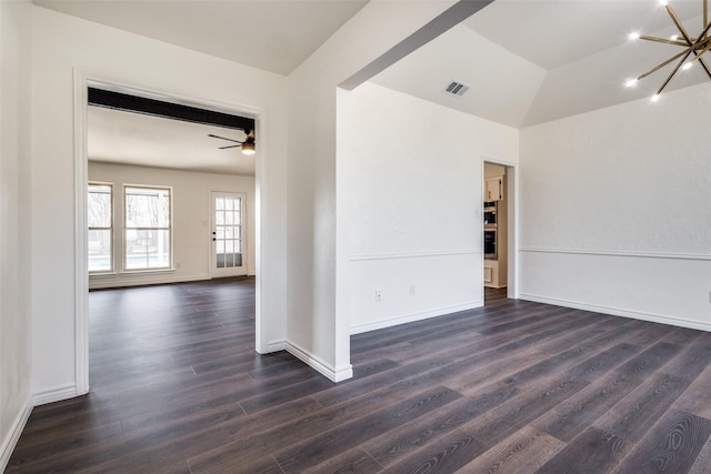 spare room featuring dark wood-style flooring, lofted ceiling, visible vents, baseboards, and ceiling fan with notable chandelier