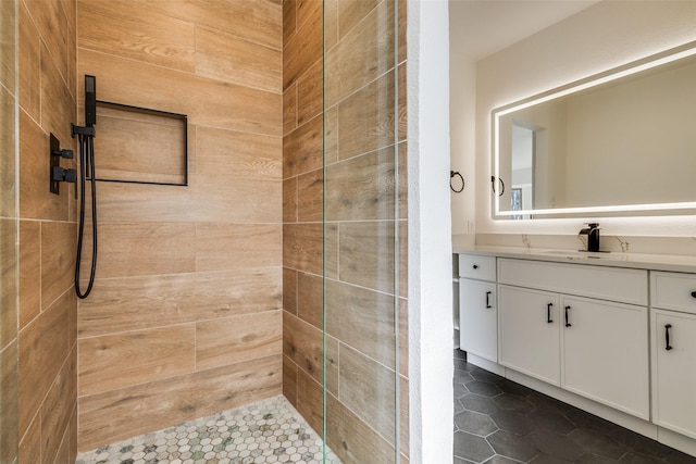 full bathroom featuring a tile shower and vanity