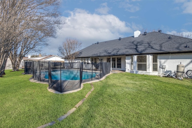 view of swimming pool featuring a lawn and a fenced in pool