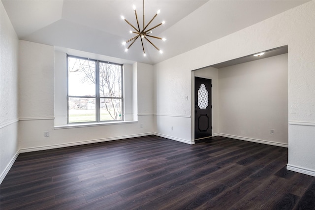 foyer entrance featuring dark wood-style floors, vaulted ceiling, a notable chandelier, and baseboards