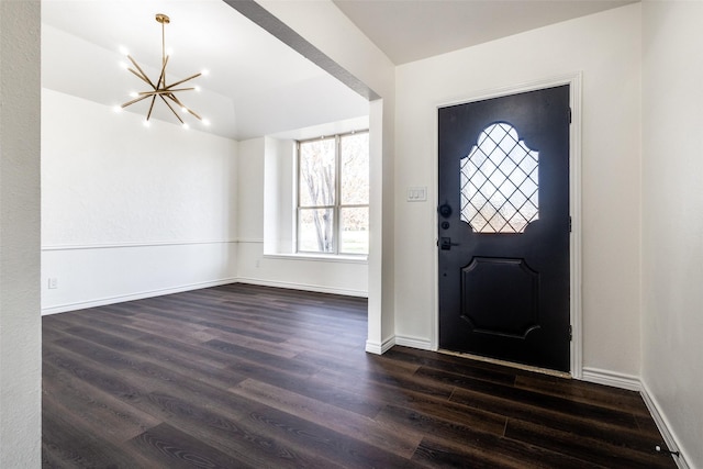 entryway featuring dark wood-style floors, an inviting chandelier, and baseboards