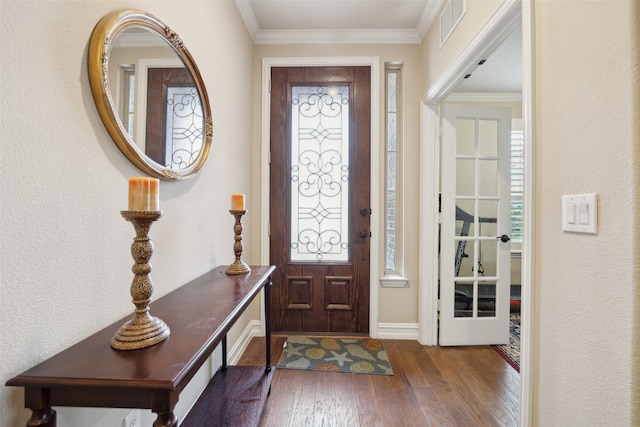 foyer with ornamental molding and hardwood / wood-style floors