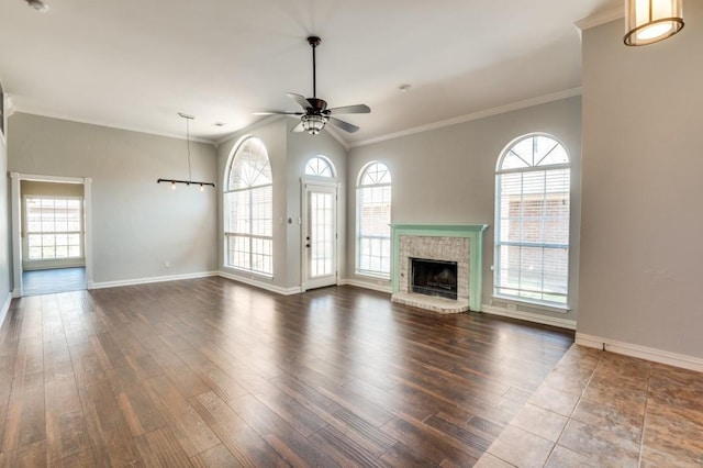 unfurnished living room featuring a ceiling fan, dark wood-style flooring, a healthy amount of sunlight, and ornamental molding