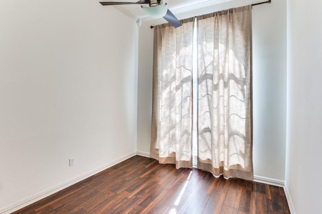 empty room featuring dark wood-style floors, ceiling fan, and baseboards