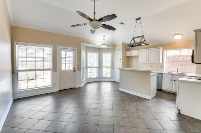 kitchen with white cabinets, a healthy amount of sunlight, ornamental molding, and light countertops