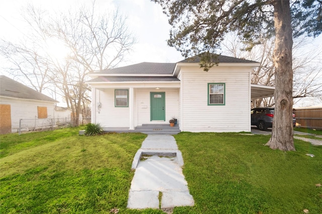 view of front of property with a front yard and a carport