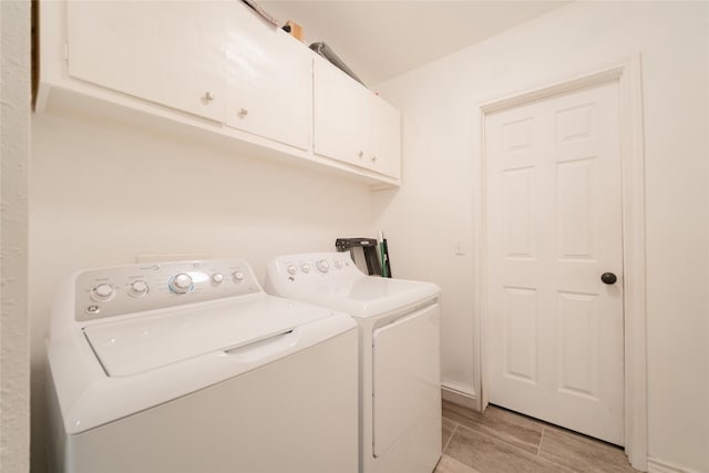 washroom with cabinets and washing machine and clothes dryer