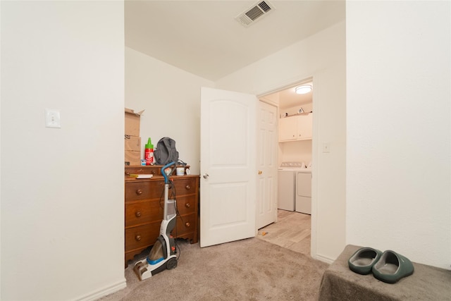 carpeted bedroom featuring washer and dryer