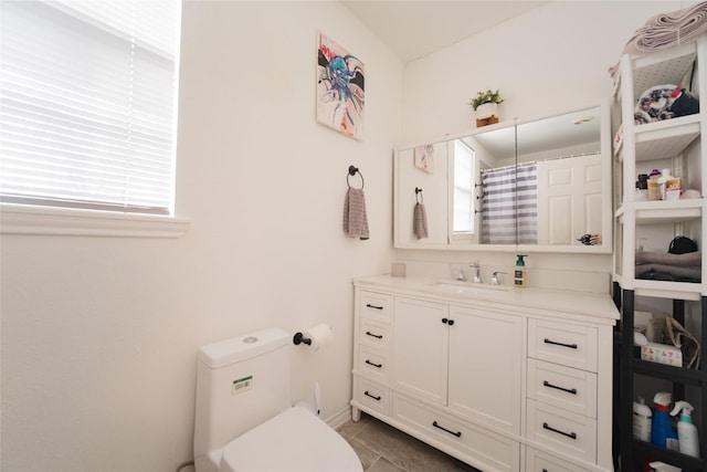 bathroom with vanity, plenty of natural light, tile patterned floors, and toilet