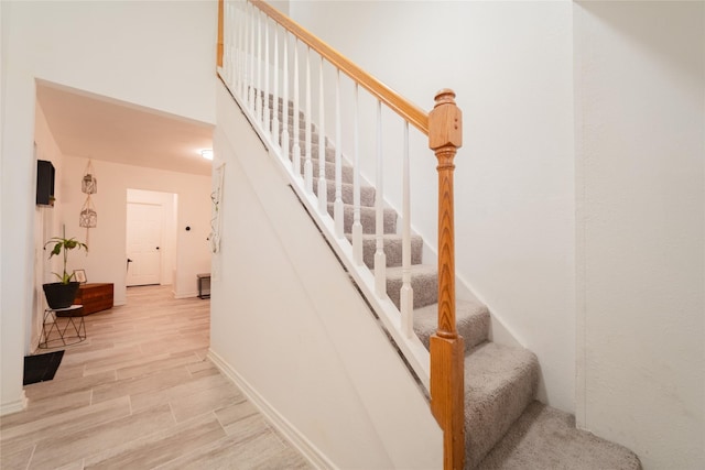 staircase with hardwood / wood-style floors